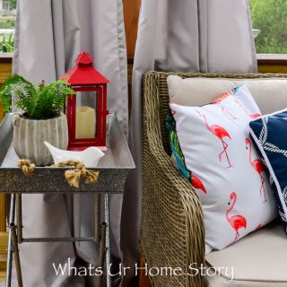 Love this outdoor space with a beautiful red and blue outdoor decor with a flamingo pillow, metal tray side table, and loads of green plants